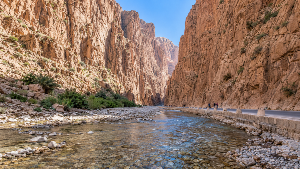 Río que corre entre los imponentes acantilados de la garganta del Todra en Marruecos