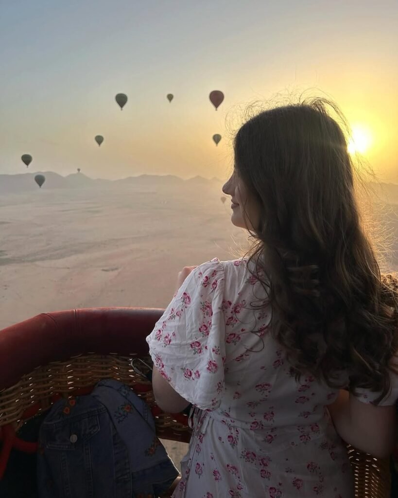 Serenity Sahara guest smiling in a hot air balloon at sunrise near Marrakech